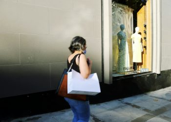 woman in white shirt and blue denim jeans standing in front of mirror