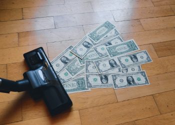 a pile of money sitting on top of a wooden floor